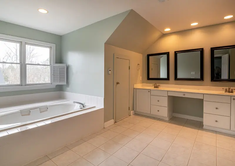 Bathroom with a fitted bath, tiled floor and a vanity unit with mirrors